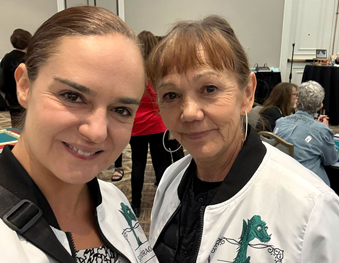 Mother and daughter at a Mahjong Baby gathering smiling in coordinated dragon-design jackets Mother and daughter at a Mahjong Baby gathering smiling in coordinated dragon-design jackets