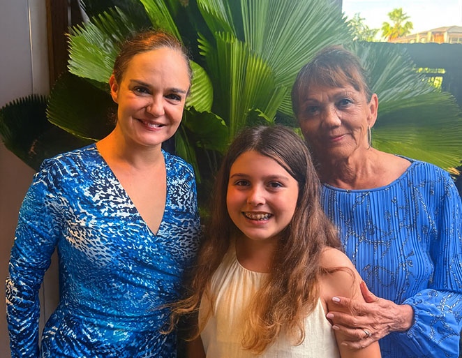 Three generations smiling together outdoors in front of large green tropical leaves, featured on the Mahjong Baby About Us page Three generations smiling together outdoors in front of large green tropical leaves, featured on the Mahjong Baby About Us page