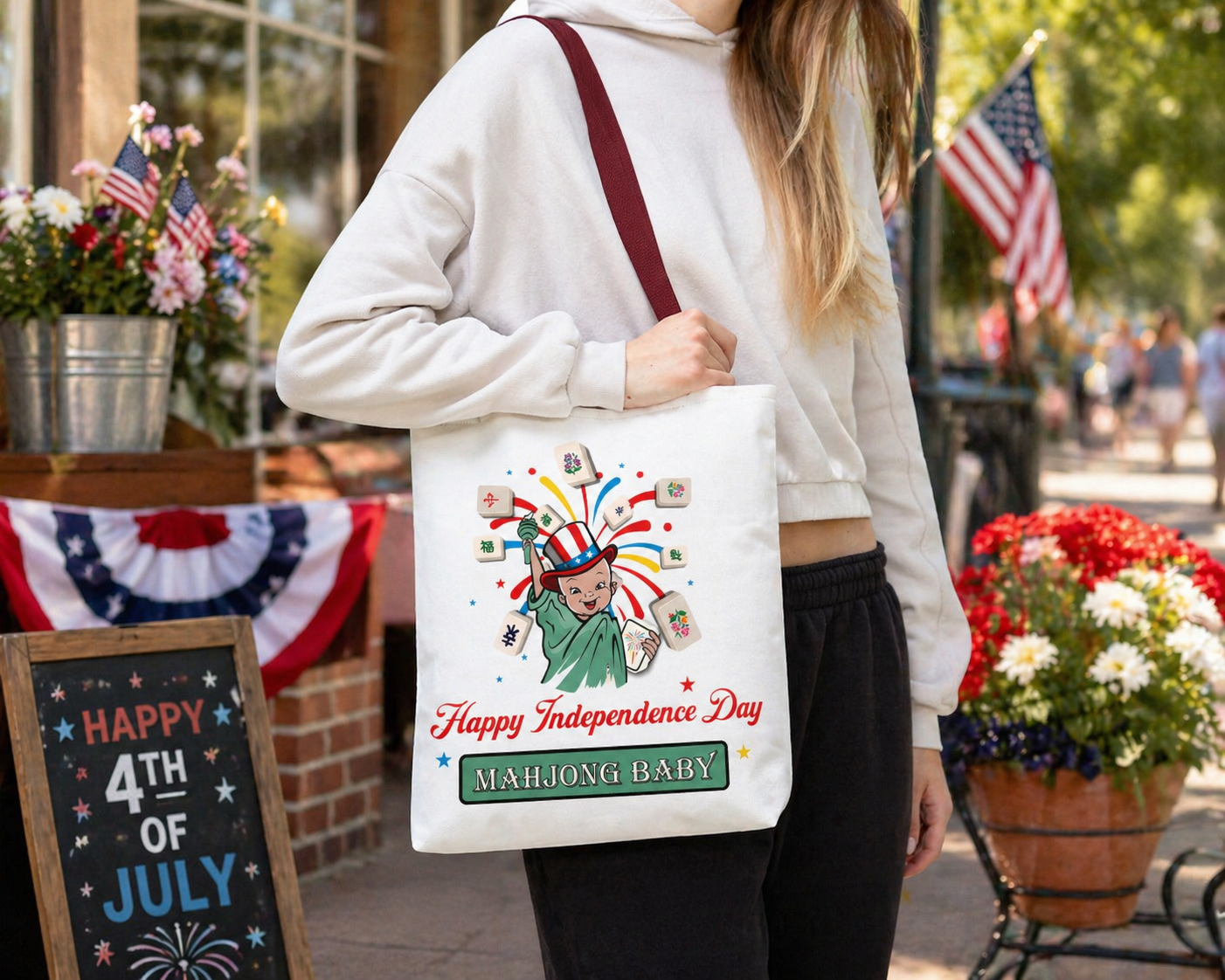 Mahjong Baby 4th of July tote bag worn by woman outdoors, patriotic mahjong tote with Lady Liberty design, Independence Day market bag